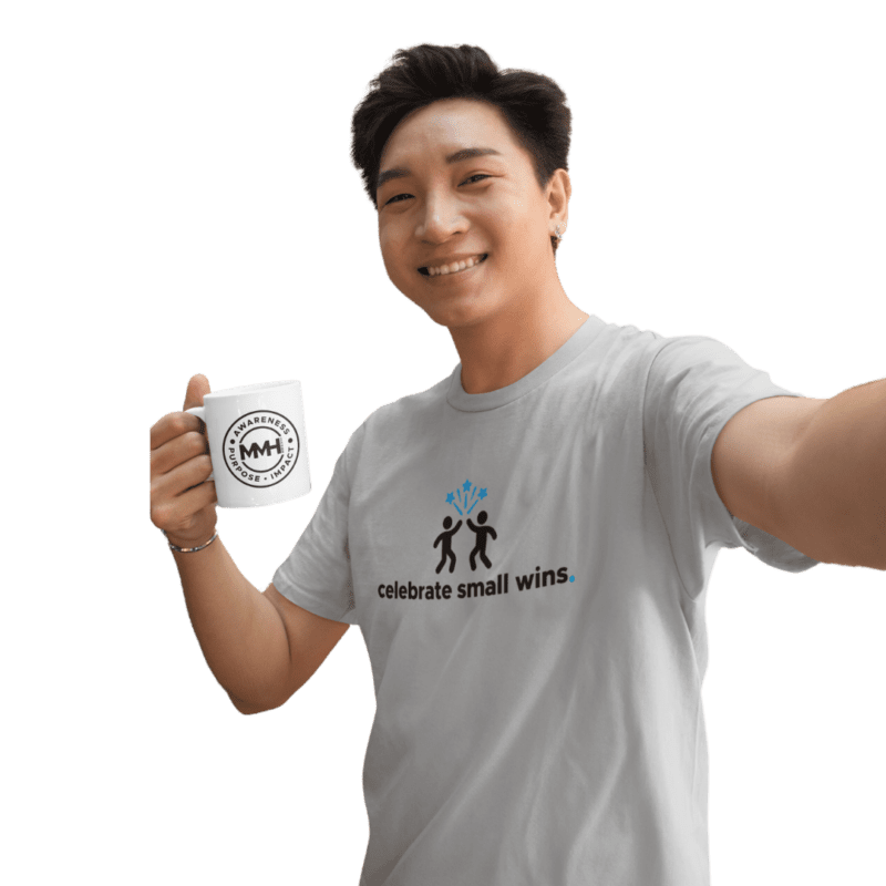 Smiling person holding mug, wearing motivational T-shirt.