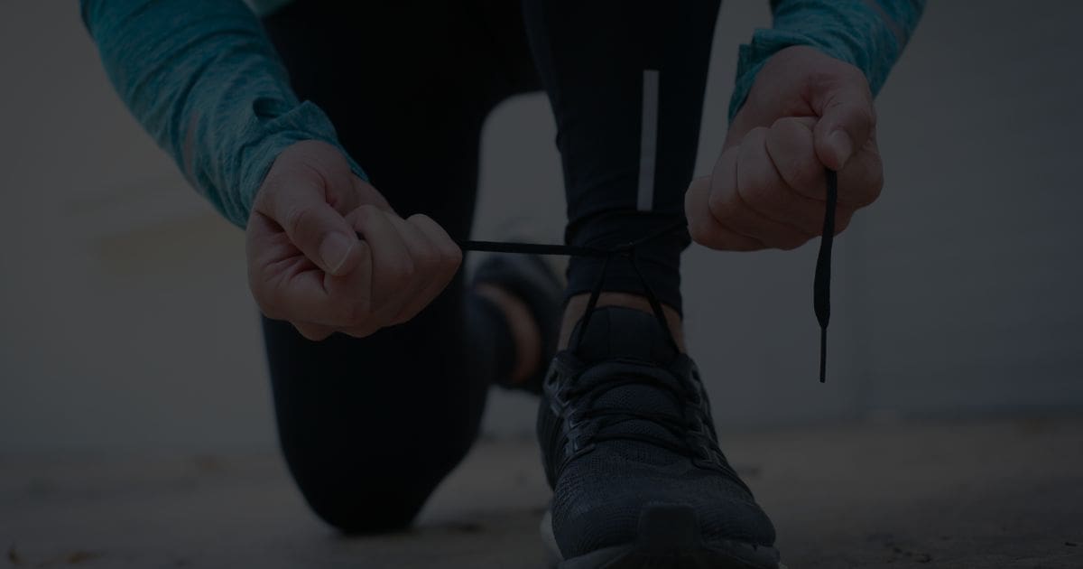A runner tying shoelaces before a half marathon — symbolising Scott's journey to support men’s mental health through The Proper Blokes Club