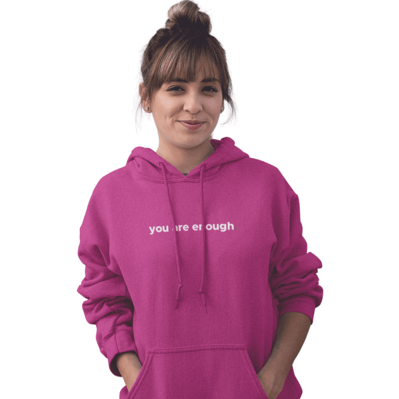 Person in pink hoodie with 'you are enough' text.