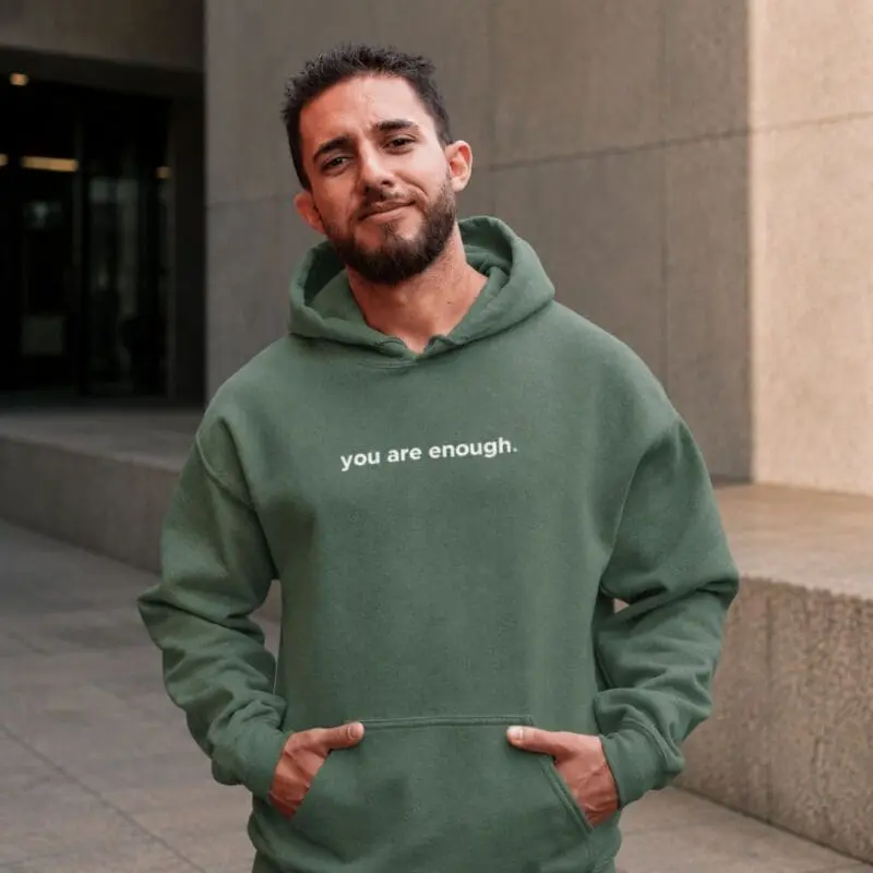 Man wearing green hoodie with positive slogan