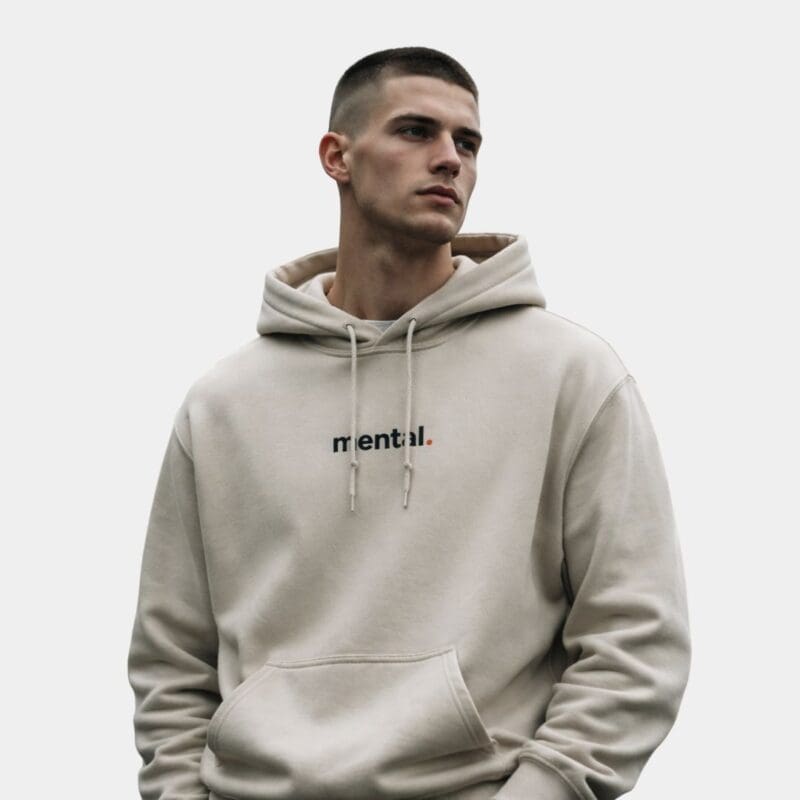 Person wearing beige hoodie with 'mental' text.