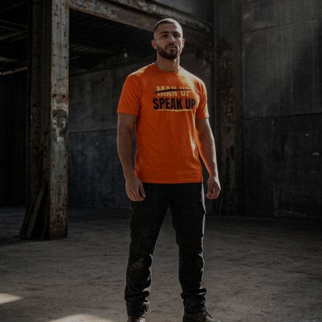 don-man-up-speak-up-t-shirt-factory Man wearing orange Speak Up T-shirt indoors