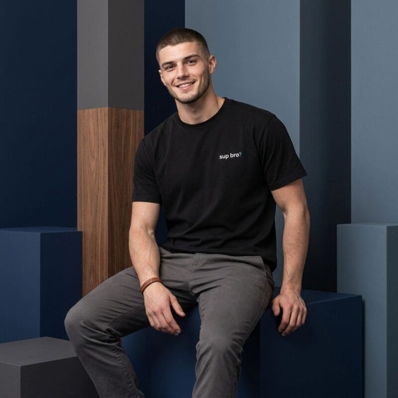Smiling man in black T-shirt seated indoors