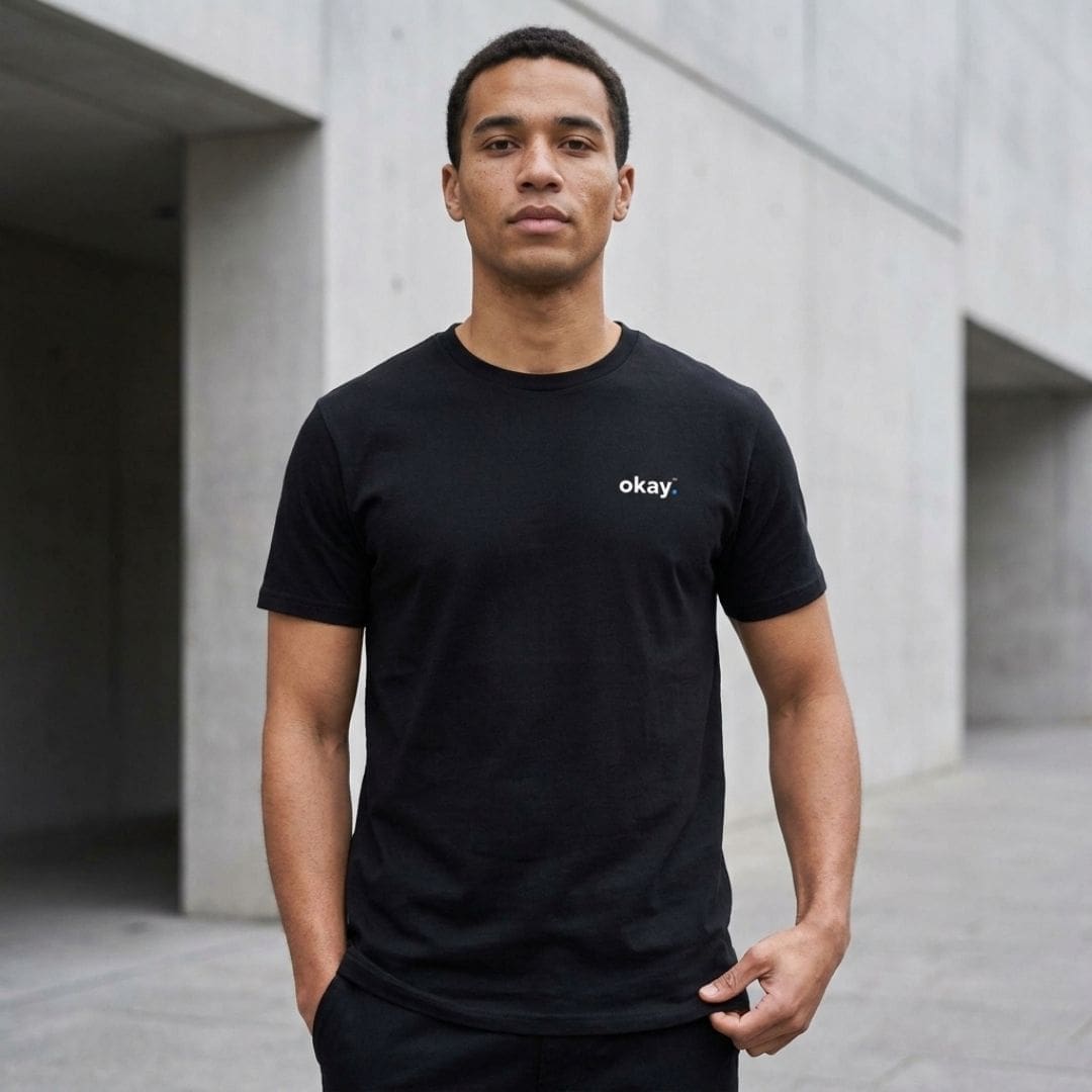Man wearing black 'okay.' T-shirt outdoors