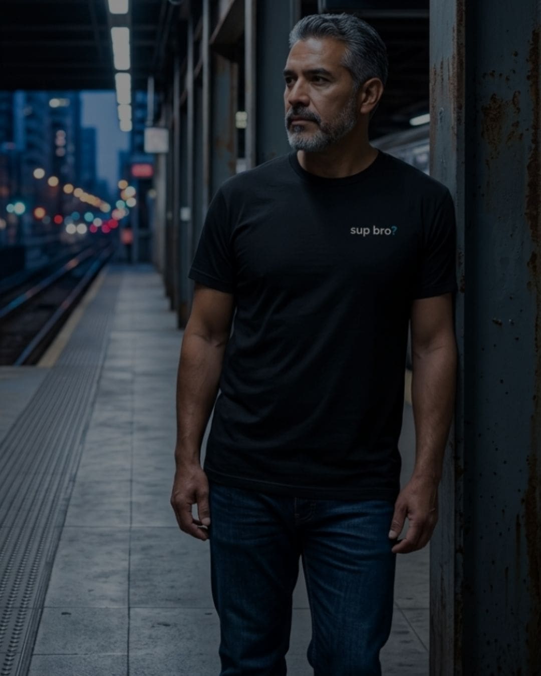 Man on city train platform at night