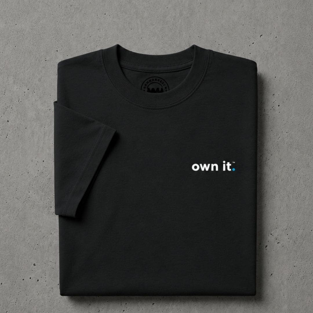 Folded black T-shirt with 'own it.' slogan