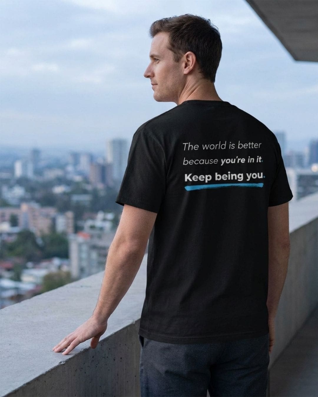 Man wearing inspirational quote T-shirt overlooking city